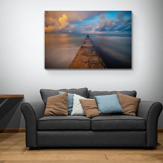 Fotografía de larga exposición de un muelle que se adentra en un océano tranquilo al atardecer