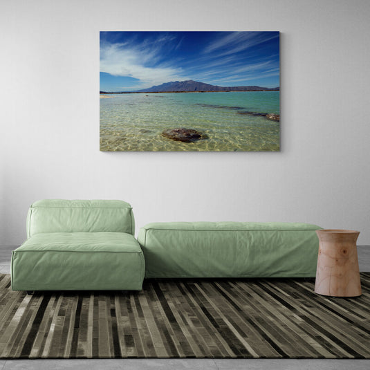Playa desierta con montaña y cielo azul