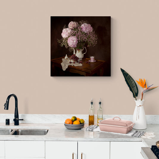 Arreglo de hortensias rosadas y uvas sobre mesa de madera