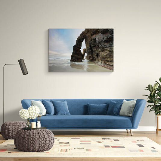 Arco natural en una playa con formaciones rocosas y marea baja