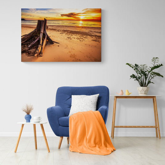 Fotografía de atardecer con tronco en playa desierta"