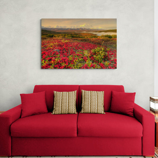 Paisaje ártico con flores rojas y montañas nevadas