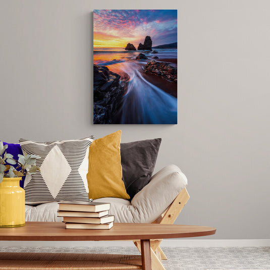 Fotografía de larga exposición en la playa al amanecer con rocas y cielo colorido
