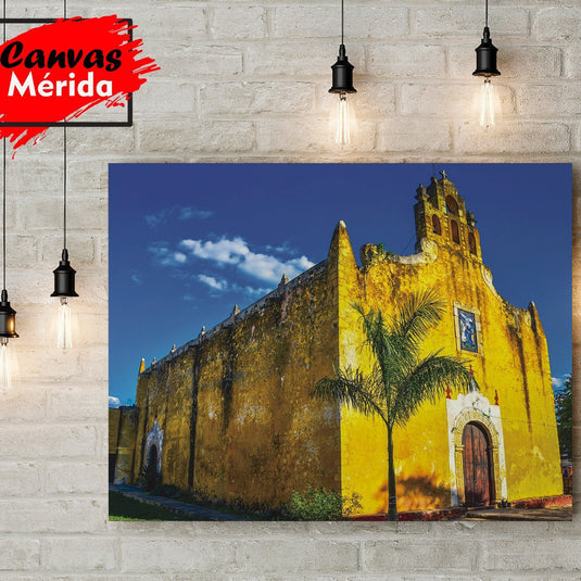 Iglesia colonial amarilla con campanario y palma