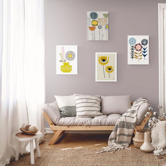 Set de cuadros minimalistas: tres con fondo blanco y flores en tonos grises, rosas, azules y naranjas; uno con marialuisa blanca sobre fondo amarillo pastel y flores amarillas.