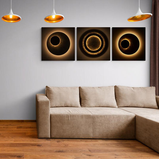 Tríptico abstracto con círculos concéntricos en tonos dorados y sombras que evocan fases solares