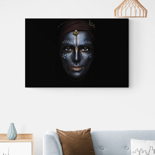 Retrato artístico de rostro con maquillaje creativo en tonos azules y adornos dorados sobre fondo oscuro