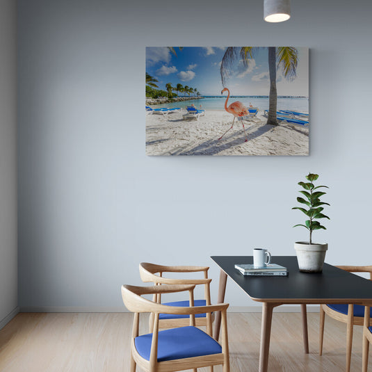 Flamenco rosa caminando por la playa con sillas de playa y palmeras alrededor