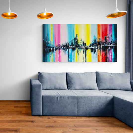 Cuadro abstracto de skyline urbano con colores vibrantes en una sala moderna.