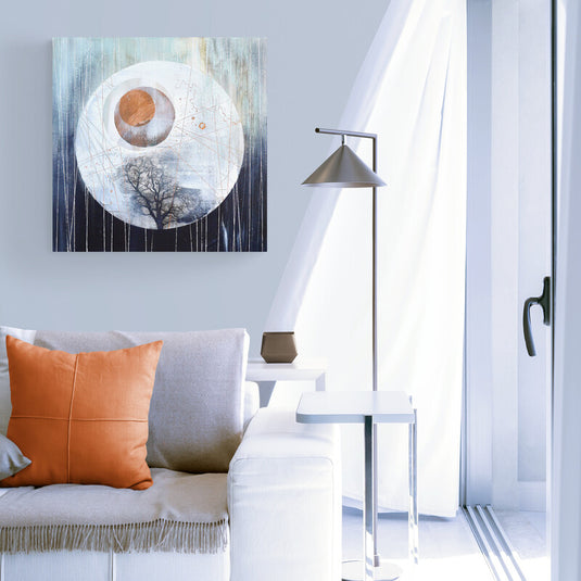 Cuadro abstracto con diseño cósmico en una sala moderna y luminosa con detalles minimalistas.