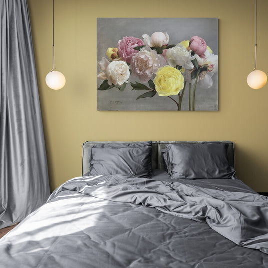 Ramo de peonías en tonos pastel sobre fondo gris.