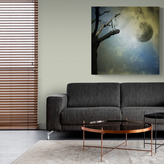 Cuadro de cielo nublado con luna llena en tonos azules y amarillos pálidos, árbol deshojado y pájaro blanco posado