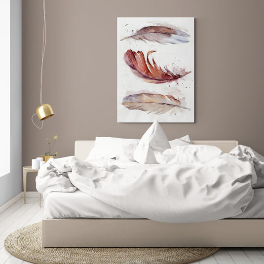 Cuadro decorativo con tres plumas horizontales en colores café con blanco, rojo y crema sobre fondo blanco