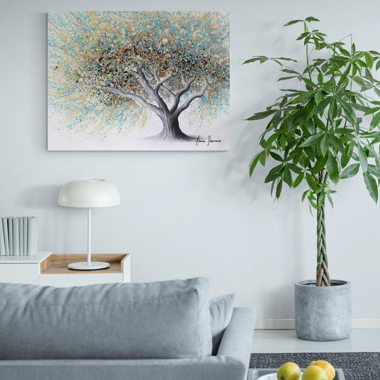 Cuadro decorativo con tronco gris y ramas con hojas en tonos arena y turquesa sobre fondo blanco