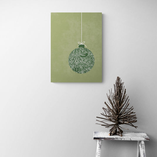 Adorno navideño colgante con diseño detallado en tonos verdes sobre fondo suave, que combina la tranquilidad y la tradición de la temporada festiva