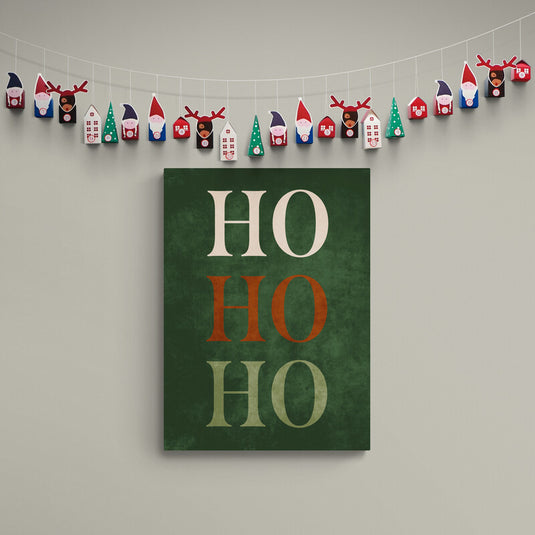 Lienzo con las palabras 'HO HO HO' en colores marfil, rojo y verde sobre fondo texturizado