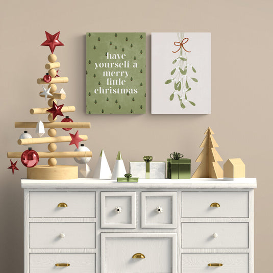 Dúo de cuadros navideños minimalistas con mensaje tipográfico moderno y muérdago estilizado en tonos verdes y rojo terroso para decoración festiva