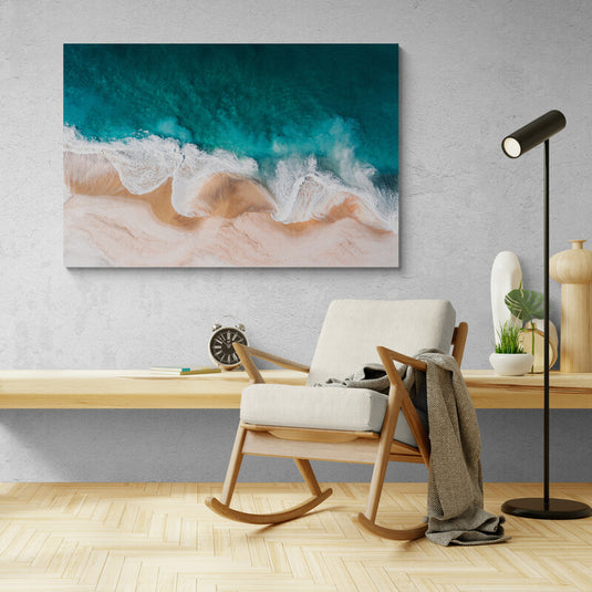 Vista aérea de la interacción de olas espumosas con la playa y el océano turquesa.