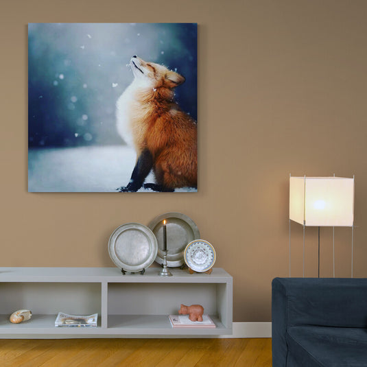 Pequeño zorro disfrutando de la nieve mientras los copos caen en su nariz