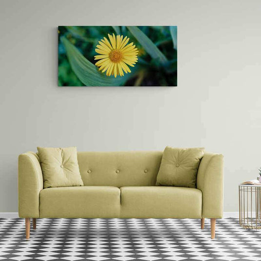 Primer plano de una flor amarilla con fondo de hojas verdes difuminadas.