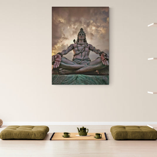 Escultura de Shiva en postura de meditación con un cielo dramático al fondo, simbolizando serenidad y transformación espiritual.