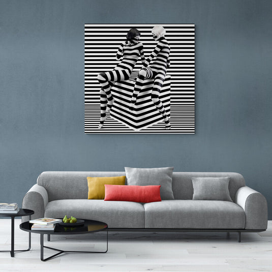 Fotografía en blanco y negro de dos modelos con atuendos a rayas en un entorno de ilusión óptica