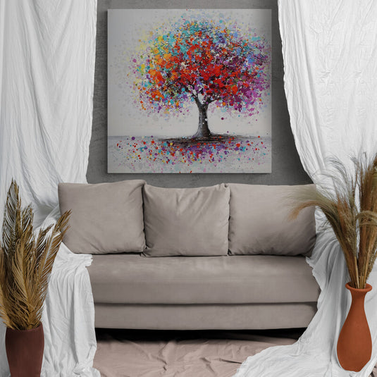 Cuadro_decorativo_árbol_multicolor_sobre_fondo_gris_con_pétalos_coloridos_en_el_suelo