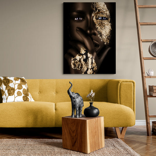 Retrato fotográfico de mujer con hoja de oro en el rostro y la mano, creando un contraste dramático