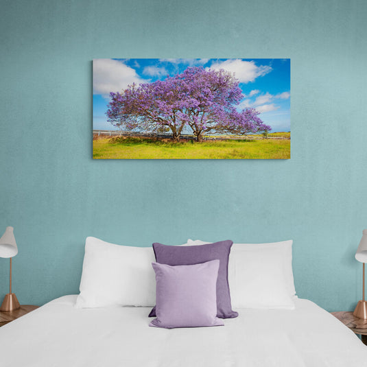 Cuadro decorativo de paisaje con césped y árbol prominente de hojas moradas.