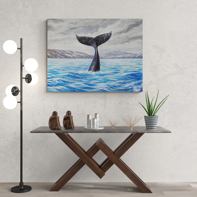 Pintura de la cola de una ballena emergiendo de aguas azules con montañas distantes