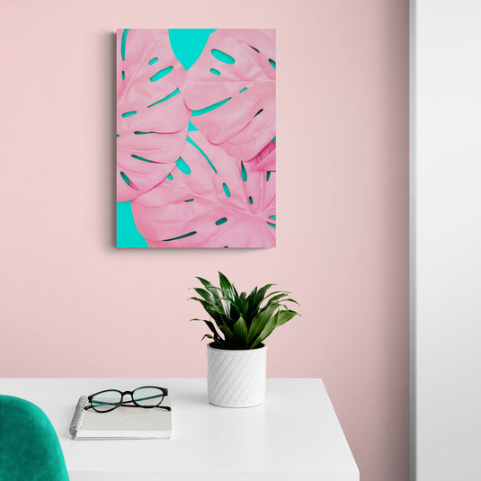 Cuadro de hojas de monstera en rosa pastel con fondo turquesa.