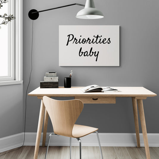  Arte tipográfico en blanco y negro con el mensaje "Priorities baby" para oficina.