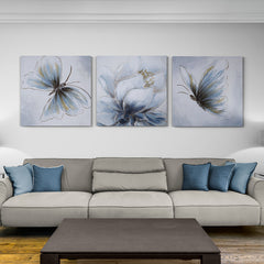 Tríptico de pinturas con flores y mariposas en tonos de azul y detalles dorados.