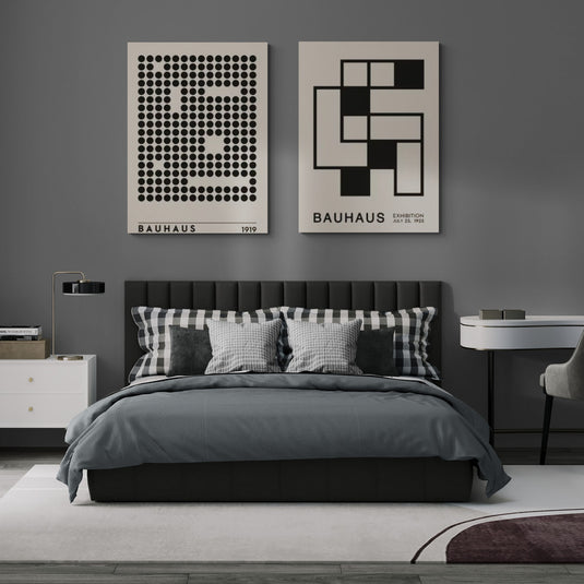 Cuadros de estilo Bauhaus en blanco y negro con patrones geométricos en una habitación moderna con cama y decoración en tonos grises y verdes.