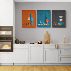Arte de pared tríptico con las palabras 'eat', 'drink', 'love' y símbolos relacionados