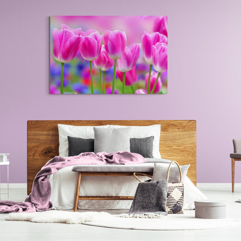 Fotografía de tulipanes rosas en primer plano con un fondo borroso de jardín florido