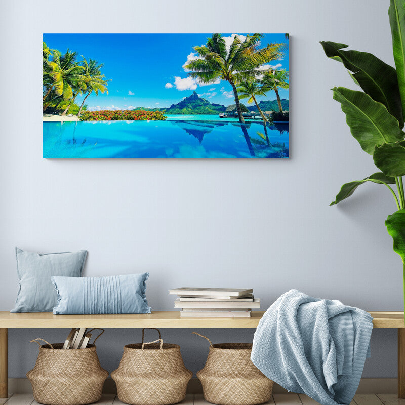 Fotografía panorámica de una piscina infinita con palmeras y una montaña tropical en el fondo