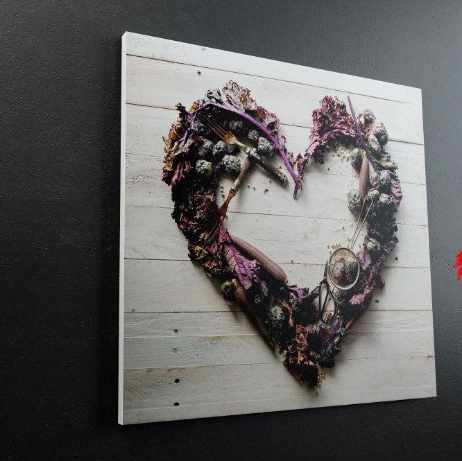 Corazón artístico con flores y utensilios en tonos púrpuras sobre fondo de madera