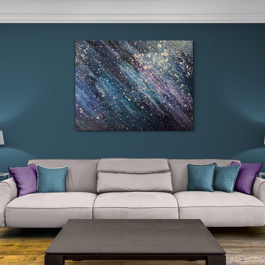 Cuadro abstracto moderno con efecto de galaxia en azul, púrpura y blanco sobre pared azul.