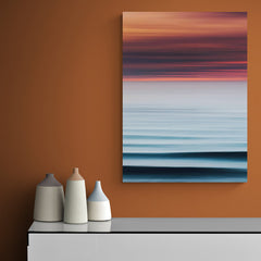 Mar tranquilo al atardecer con tonos rojizos y azules en composición abstracta horizontal
