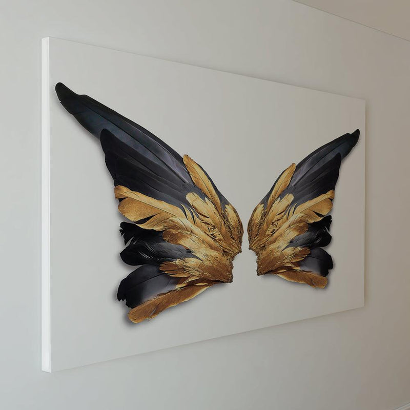 Cuadro decorativo de alas negras con detalles dorados sobre fondo blanco