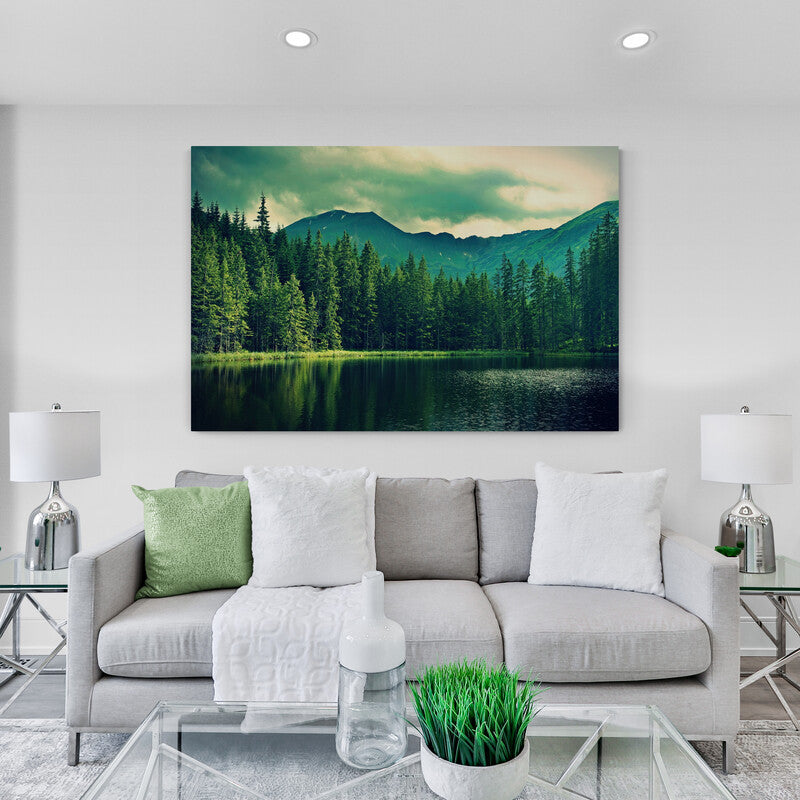 Fotografía artística de un lago tranquilo enmarcado por pinos y montañas bajo tonalidades verdes de atardecer en un paisaje natura
