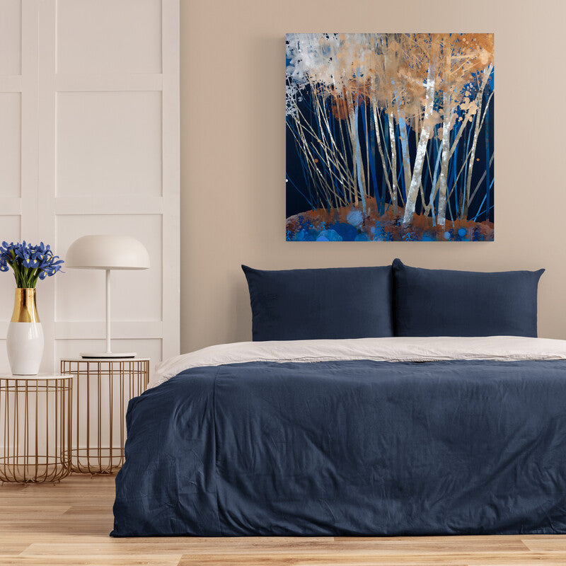 tCuadro decorativo abstracto: Fondo azul fuerte con troncos blancos y hojas blancas y naranjas en forma de telarañas.