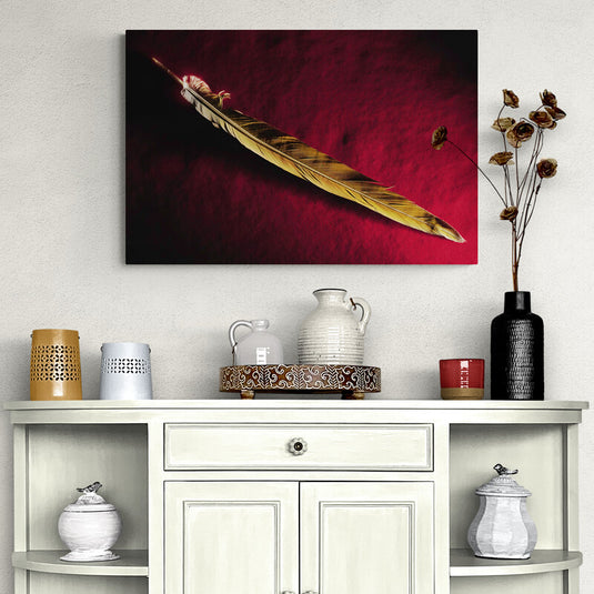 Cuadro decorativo con pluma amarilla destacada sobre fondo rojo intenso