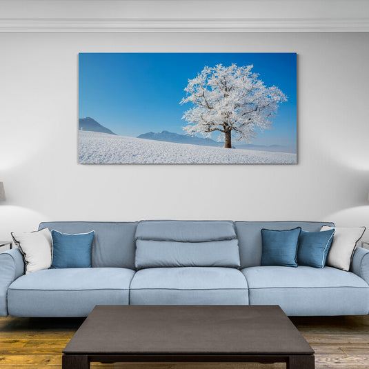 Cuadro_decorativo_fotográfico_de_paisaje_diurno_con_suelo_nevado,_montañas_a_la_distancia_y_gran_árbol_cubierto_de_nieve