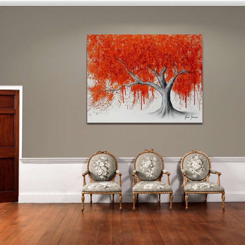 Cuadro decorativo con tronco gris y hojas de color naranja sobre fondo blanco.