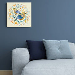 Pájaros amarillos y azules en círculo decorativo con ramas azules, flores naranjas y azules sobre fondo amarillo pastel
