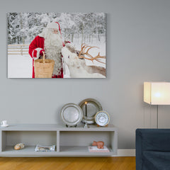 Santa Claus en traje rojo alimentando a un reno en un bosque nevado