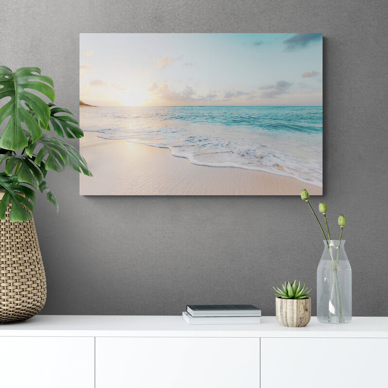 Fotografía de playa al amanecer con suaves olas y cielo colorido