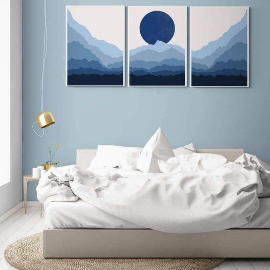 Tríptico minimalista con montañas escalonadas y círculo central en tonos azules